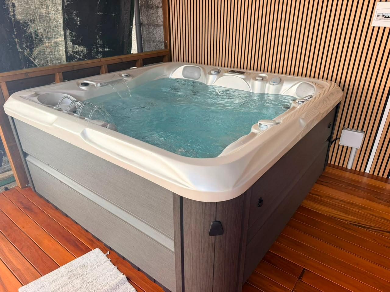 Spa rempli d'eau devant un mur en bois, Run Spas Réunion